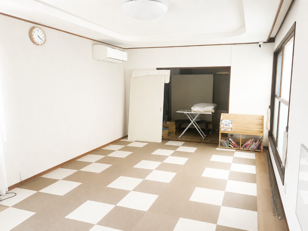 放課後等デイサービスの室内。収納棚と明るい窓のあるスペース
